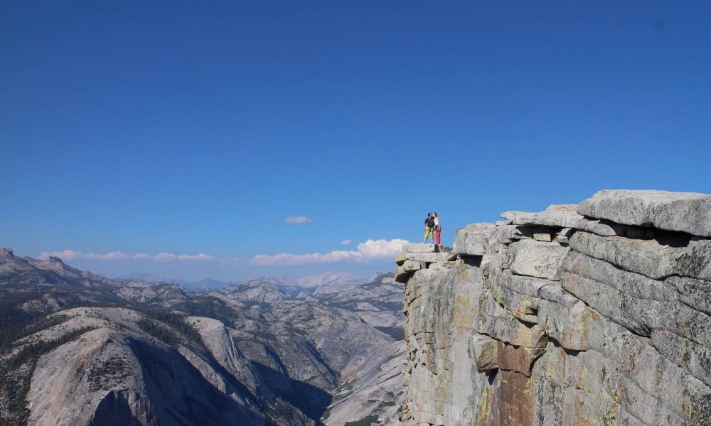Nicole Reeve and her husband stand on Half Dome in Yosemite National Park, California, America