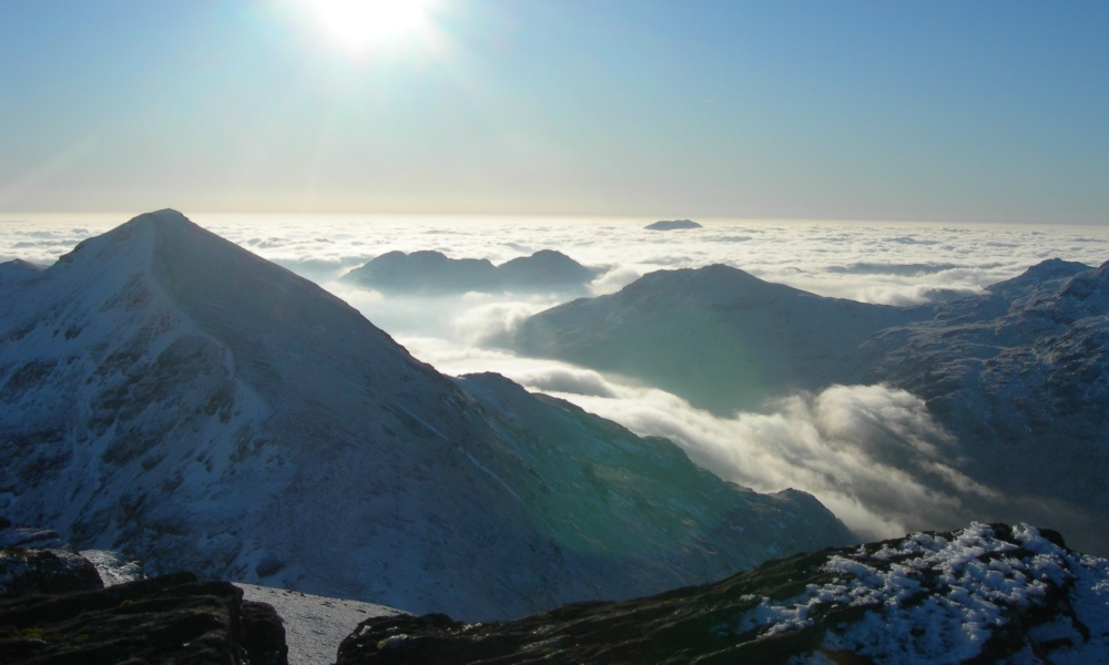 A temperature inversion in snowy Scottish mountains. A sea of clouds stretch far into the distance.