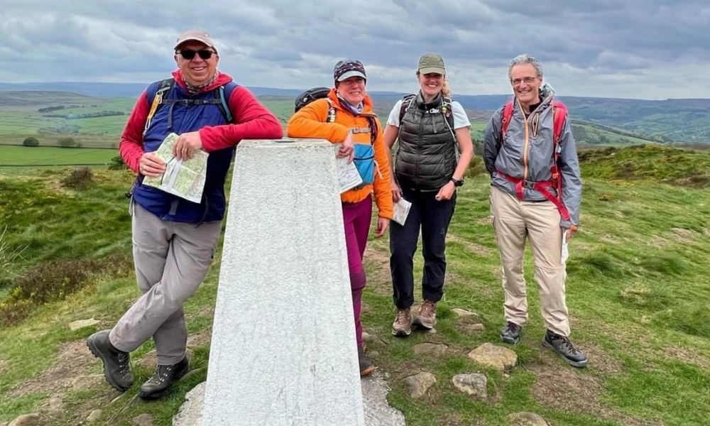 Amy Baron Hall with fellow Hill and Moorland Leader trainees at a trigpoint.