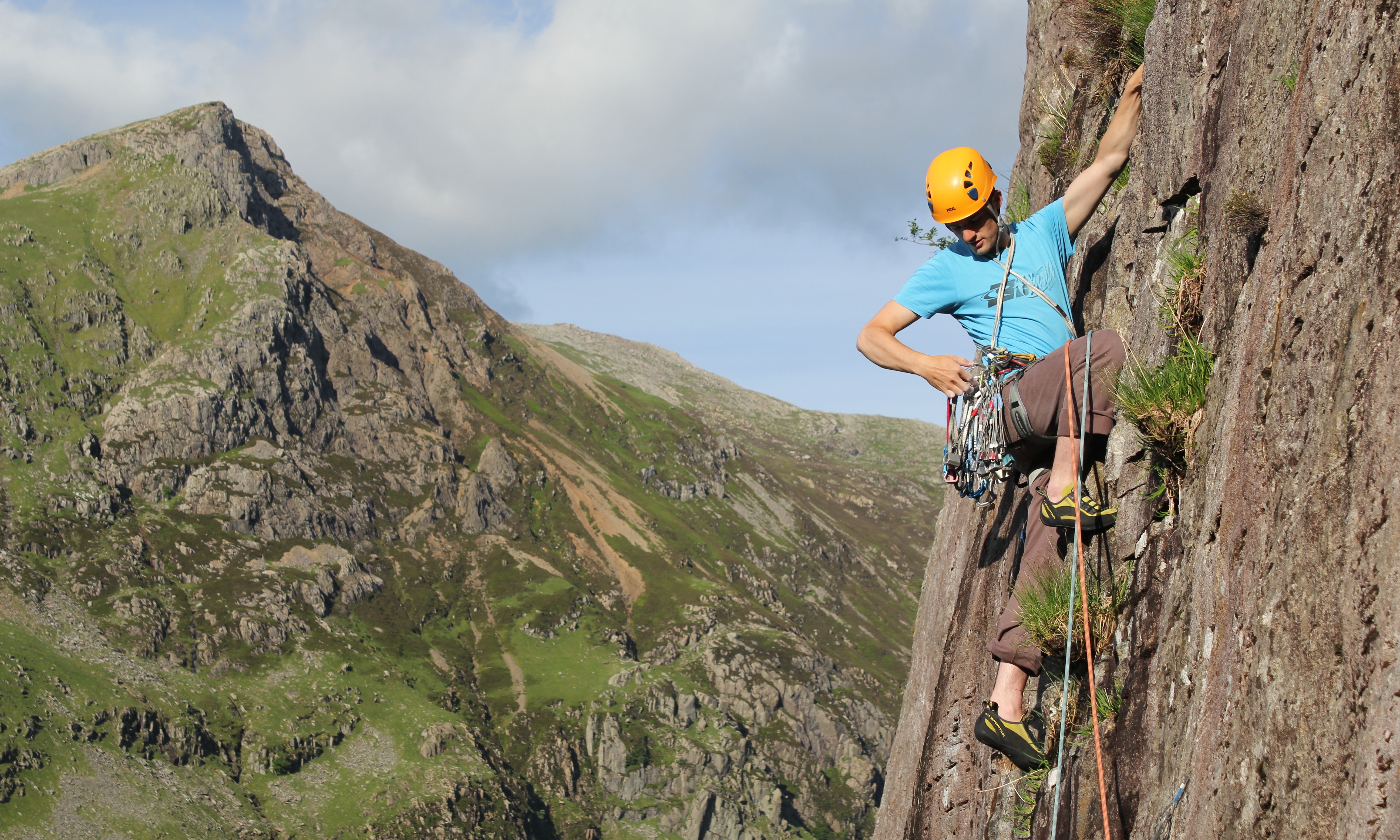 A man leading a trad climb