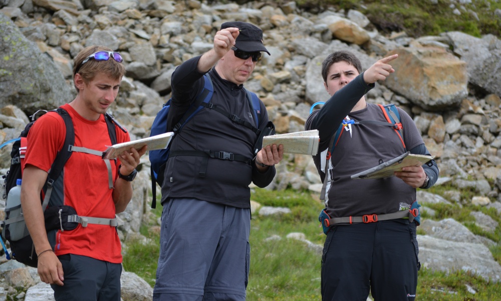 Three people consulting maps and confering